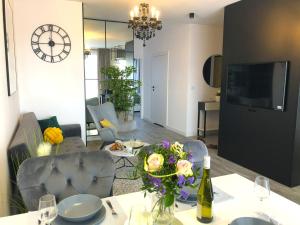 salon ze stołem i wazą kwiatów w obiekcie Glamour Apartment with big, private terrace w Krakowie