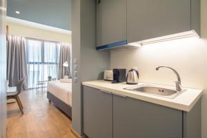 een keuken met een wastafel en een kamer met een bed bij Kolokotroni Lofts Syntagma in Athene