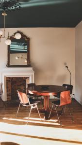 jadalnia ze stołem, krzesłami i kominkiem w obiekcie La Passerelle de Pont-Aven w mieście Pont-Aven