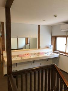 a bathroom with a sink and a large mirror at Oyado Zen in Kusatsu