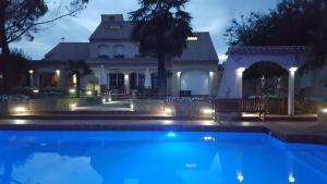 a swimming pool in front of a house at night at Le Mas Champenois in Châlons-en-Champagne