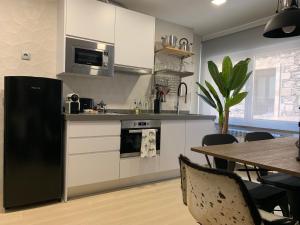 a kitchen with a black refrigerator and a table at Homely Salamanca in Salamanca