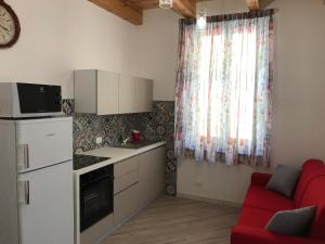 a kitchen with a red couch and a red chair at LA DIMORA SICILIANA APPARTAMENTI in Trapani