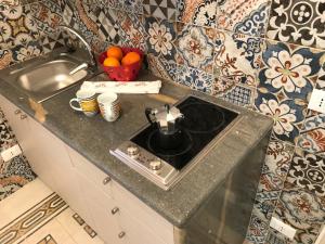 a kitchen counter with a tea pot on a stove at LA DIMORA SICILIANA APPARTAMENTI in Trapani +87 photos