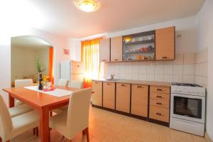 a kitchen with a table and a dining room at Holiday HomeToni in Savar