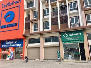 a building with several shops in front of it at Hostbox Bangkok in Lat Krabang
