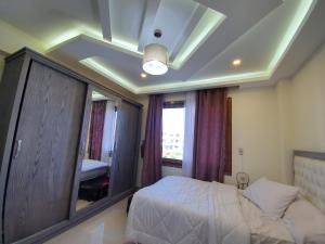 Un dormitorio con una cama y un espejo grande. en Sharm Hills Resort (Apartment), en Sharm El Sheikh
