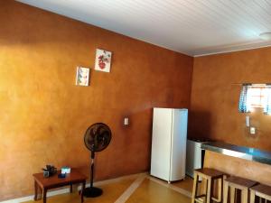 a kitchen with a refrigerator and a table in a room at Recanto do Baru in Pirenópolis