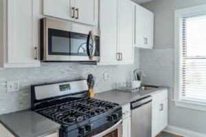 a kitchen with a stove and a microwave at Newly Decorated 1BR 1BA Convenient Apartment - Roscoe 1D in Chicago