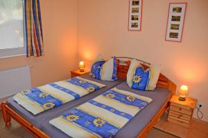 a bedroom with two beds with blue and white sheets at ruhig gelegene Ferienwohnung am Ne in Sandort