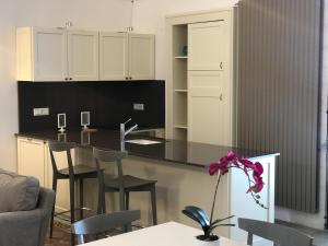 una cucina con bancone nero e alcune sedie di Casa La Stella a Martina Franca