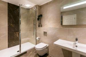 uma casa de banho com um WC, um chuveiro e um lavatório. em The Lodge @ Carus Green em Kendal