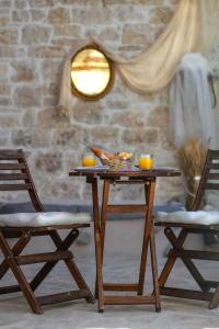 a wooden table with a bowl of food and two chairs at Paxos Fairytales Lovenest 2 in Gaios