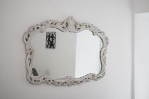 a mirror hanging on a white wall at Barbara Residenz / Apartment Clematis in Eisenerz
