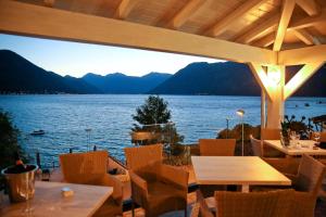 科托爾的住宿－Hotel Sara，餐厅设有桌椅,享有湖景