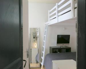 a bedroom with a bunk bed with a computer and a television at Mini Loft Del Sarte CityCosy in Paris