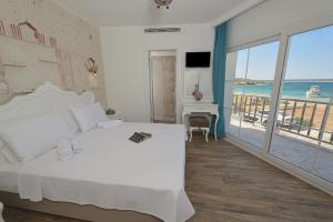 a bedroom with a bed and a view of the ocean at Alesya Otel in Çiftlikköyü
