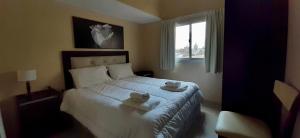 Un dormitorio con una cama con toallas. en Luxury Apart, en Villa María