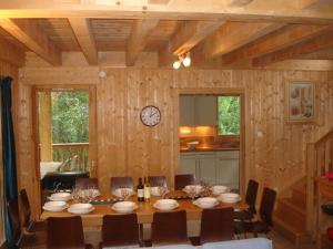 a dining room with a table and a clock on the wall at Chalet Etoile in Saint-Jean-d'Aulps