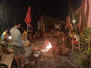 a group of people sitting around a campfire at night at Do Dee cafe in Bangkok