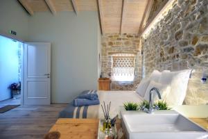uma cozinha e sala de estar com uma parede de pedra em Paxos Fairytales Lovenest 1 em Gaios