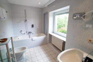 un bagno con vasca, WC e lavandino di Hotel Meyer a Beaufort