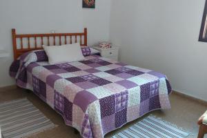 um quarto com uma colcha roxa e roxa numa cama em Surfing the Blue II em Punta del Hidalgo