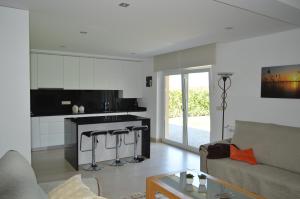 a living room with a couch and a kitchen at AL Ribeiro in Póvoa de Lanhoso