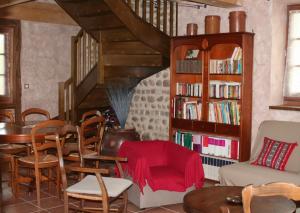 uma sala de estar com uma escada e uma mesa e cadeiras em Gîte de la Commanderie em Châtenay