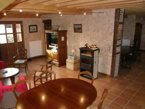 uma sala de jantar com uma mesa e cadeiras e um fogão em Gîte de la Commanderie em Châtenay