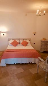 um quarto com uma cama com almofadas laranja e uma cadeira em Villa Silvana em Fasano