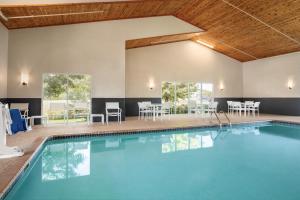 バッファローにあるCountry Inn & Suites by Radisson, Buffalo, MNのテーブルと椅子付きのホテル内のプールを利用できます。