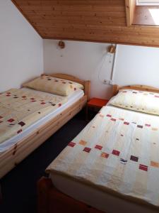 2 Betten in einem Zimmer mit Holzdecken in der Unterkunft Ferienwohnung Kerth in Sankt Kanzian am Klopeiner See