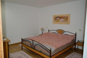 a bedroom with a bed and a painting on the wall at AL Ribeiro in Póvoa de Lanhoso