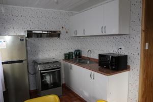 a small kitchen with a sink and a refrigerator at Laguna Verde Cabaña in Nueva Imperial