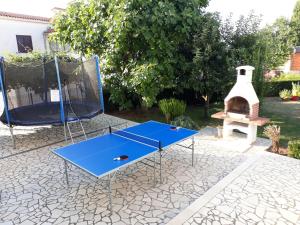 a ping pong table and a grill in a yard at Kuća za odmor - apartman Vito in Valtura