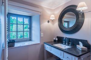 een badkamer met een wastafel en een spiegel bij Domaine du Roc in Saou