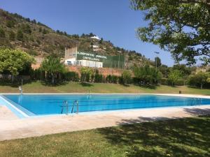 a large swimming pool in front of a hill at Casa Rural Valle del Palancia in Castellnovo