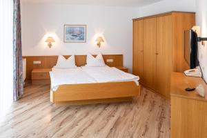 ein Hotelzimmer mit einem Bett und einem TV in der Unterkunft Gasthof Metzgerei Neumeyer in Kipfenberg