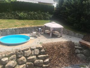 a patio with an umbrella and a swimming pool at Portus Apartment in Smržovka