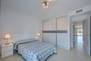 Dormitorio blanco con cama y armario en Sea Flower Beach & Golf II parking included, en Mijas Costa