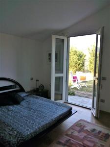a bedroom with a bed and a sliding glass door at Timo e Rosmarino in Ponte Nizza