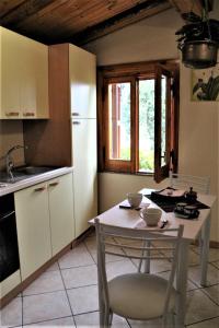 a kitchen with a table and chairs and a kitchen with a sink at Casetta Nora in Nicolosi