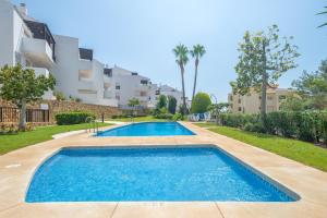 una piscina frente a un edificio de apartamentos en Sea Flower Beach & Golf II parking included, en Mijas Costa