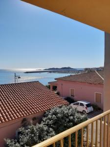 un balcón con vistas a la playa y a un coche en Isola Rossa Appartamenti Standard, en Isola Rossa