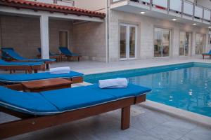 a swimming pool with blue lounge chairs next to it at Villa Amorena - Adults Only in Bol