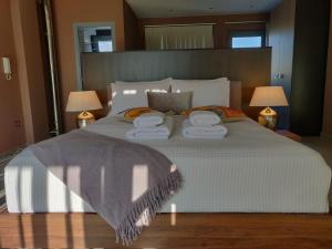 um quarto com uma cama grande e toalhas em Elegant Bright Apartment with Acropolis view terrace em Atenas