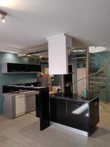 a kitchen with a black counter top and a staircase at Elegant Bright Apartment with Acropolis view terrace in Athens
