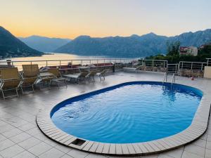 una gran piscina en un patio con vistas a las montañas en Apartman Trklja, en Kotor
