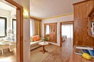 uma sala de estar com um sofá e um lavatório num quarto em Hotel Sonnenburg em Merano